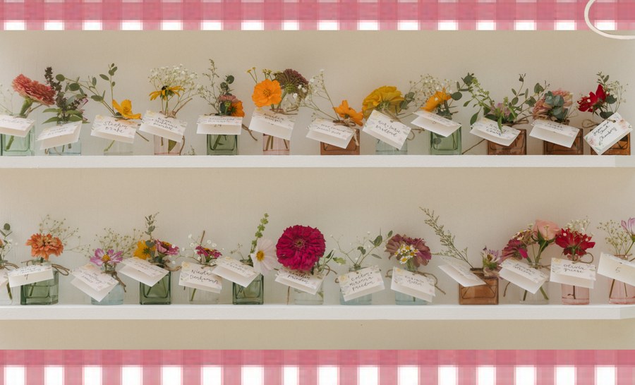 Wall display of multi-colored glass bud vases with flowers