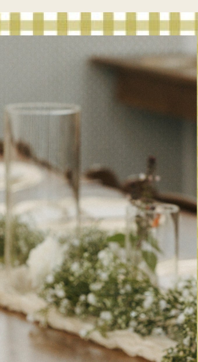Hurricane glass vases styled along a reception table