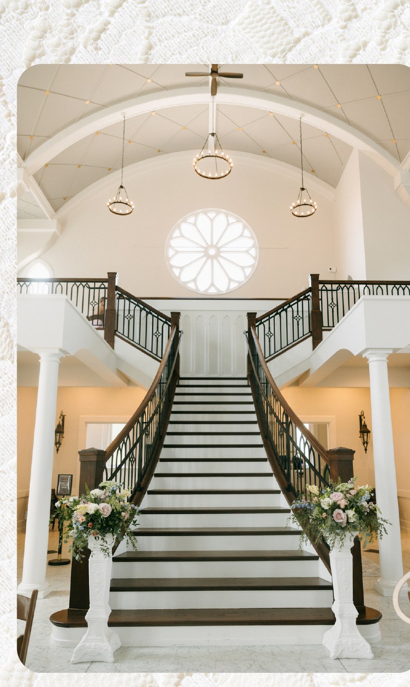 White pedestals styled with florals on a staircase