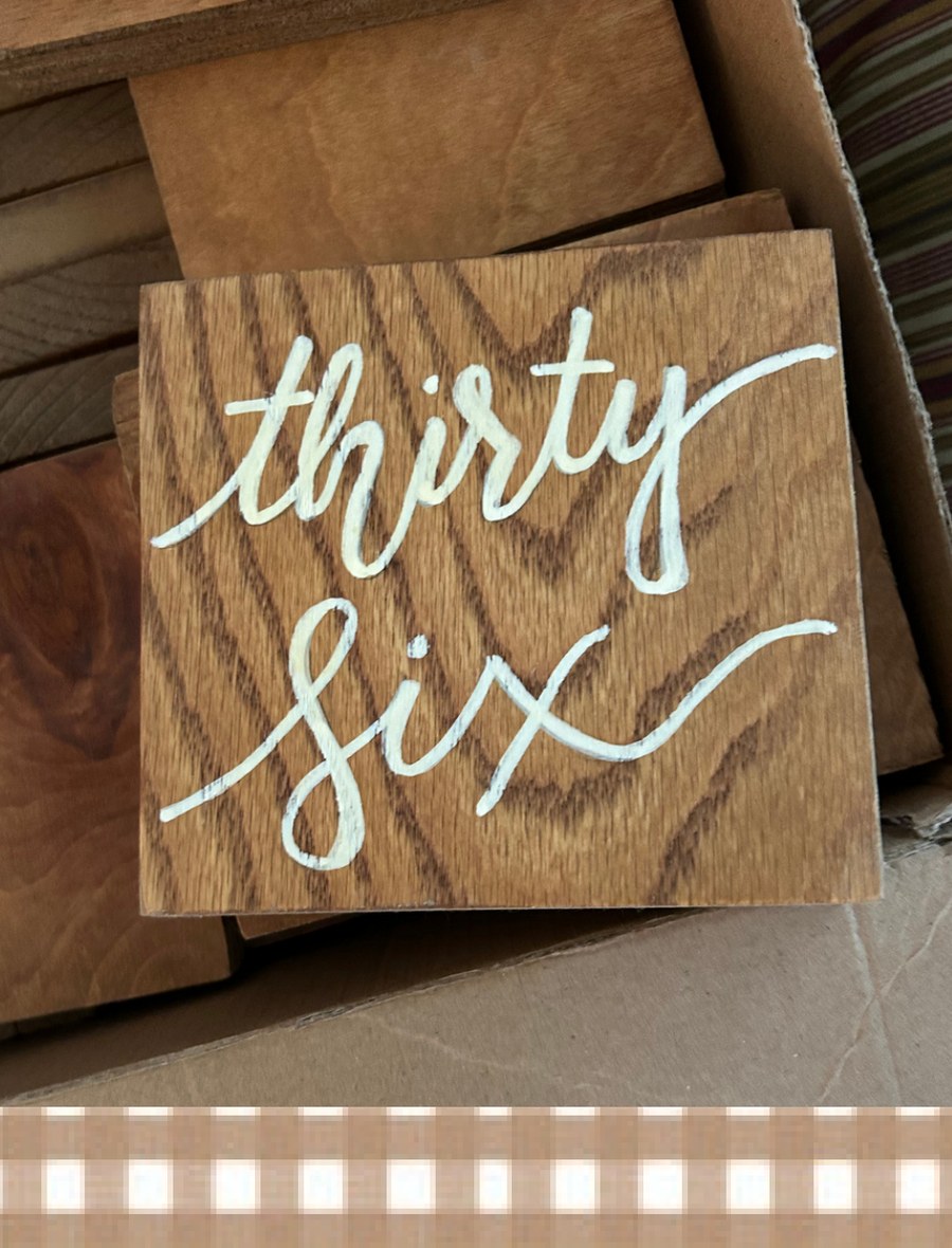 Hand-painted wooden table number reading thirty six